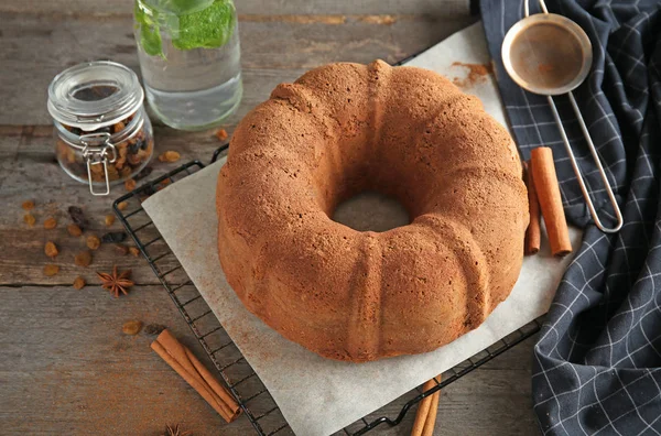 Baking rack with delicious cinnamon cake on table