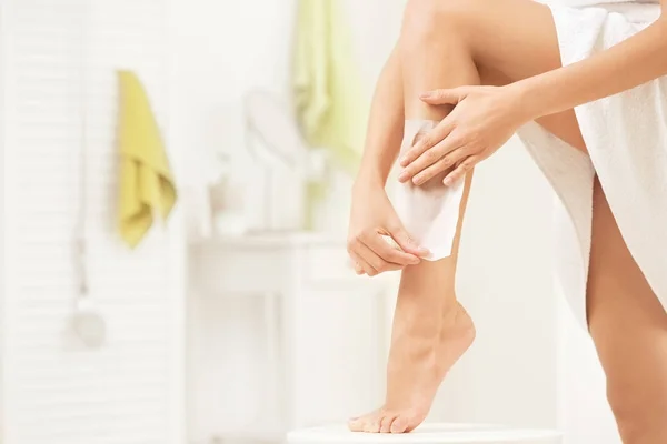 Young woman depilating leg — Stock Photo, Image