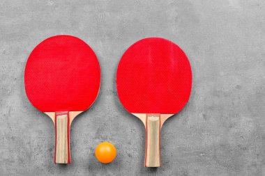 Ping pong raketleri ve gri arka plan üzerinde topu