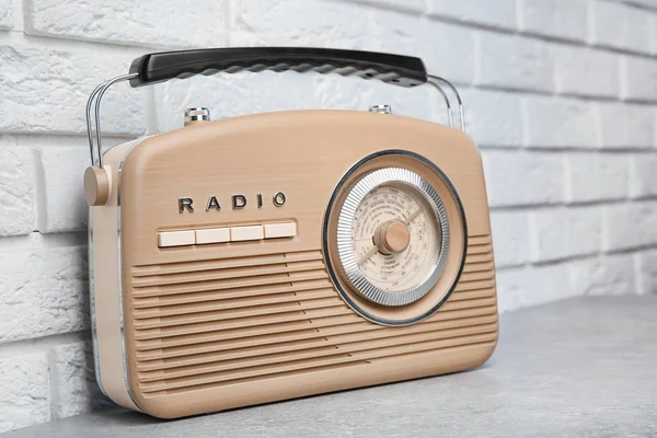 Retro radio op tafel in de buurt van bakstenen muur — Stockfoto
