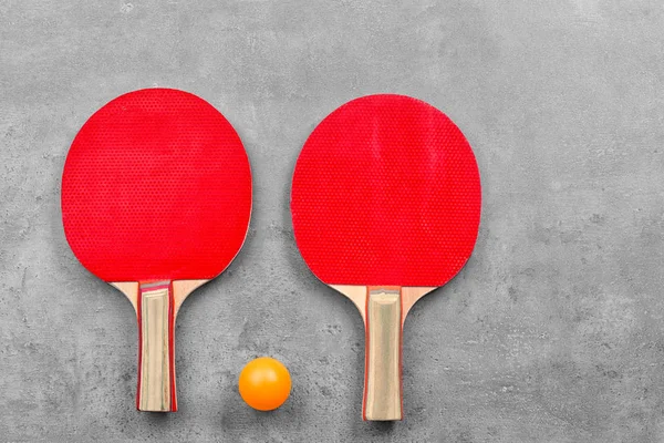 Ping pong raketleri ve gri arka plan üzerinde topu