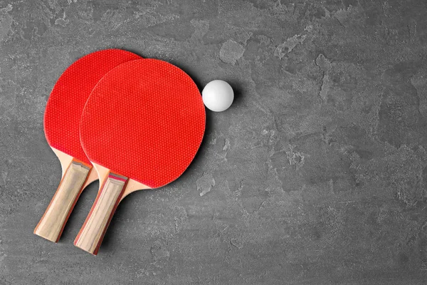 Ping pong raket dan bola di latar belakang abu-abu — Stok Foto