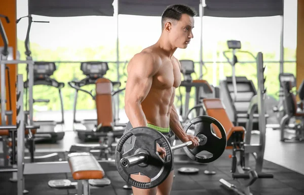 Musculoso hombre de entrenamiento con barra en el gimnasio — Foto de Stock