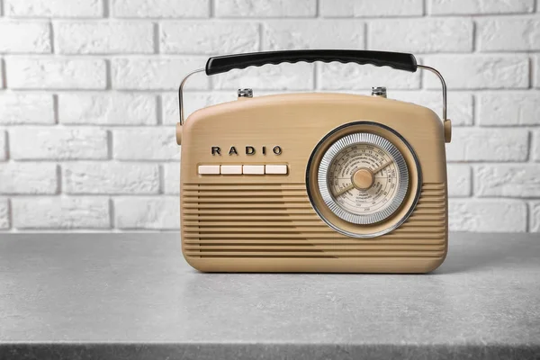 Rádio retro na mesa perto da parede de tijolo — Fotografia de Stock