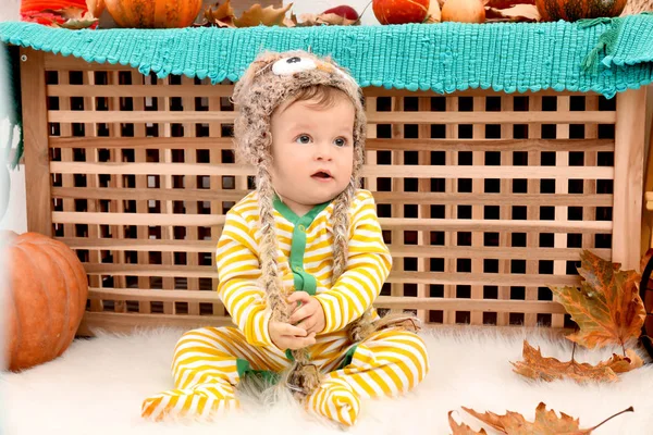Adorable bebé en sombrero de punto y pijamas a rayas en el interior — Foto de Stock