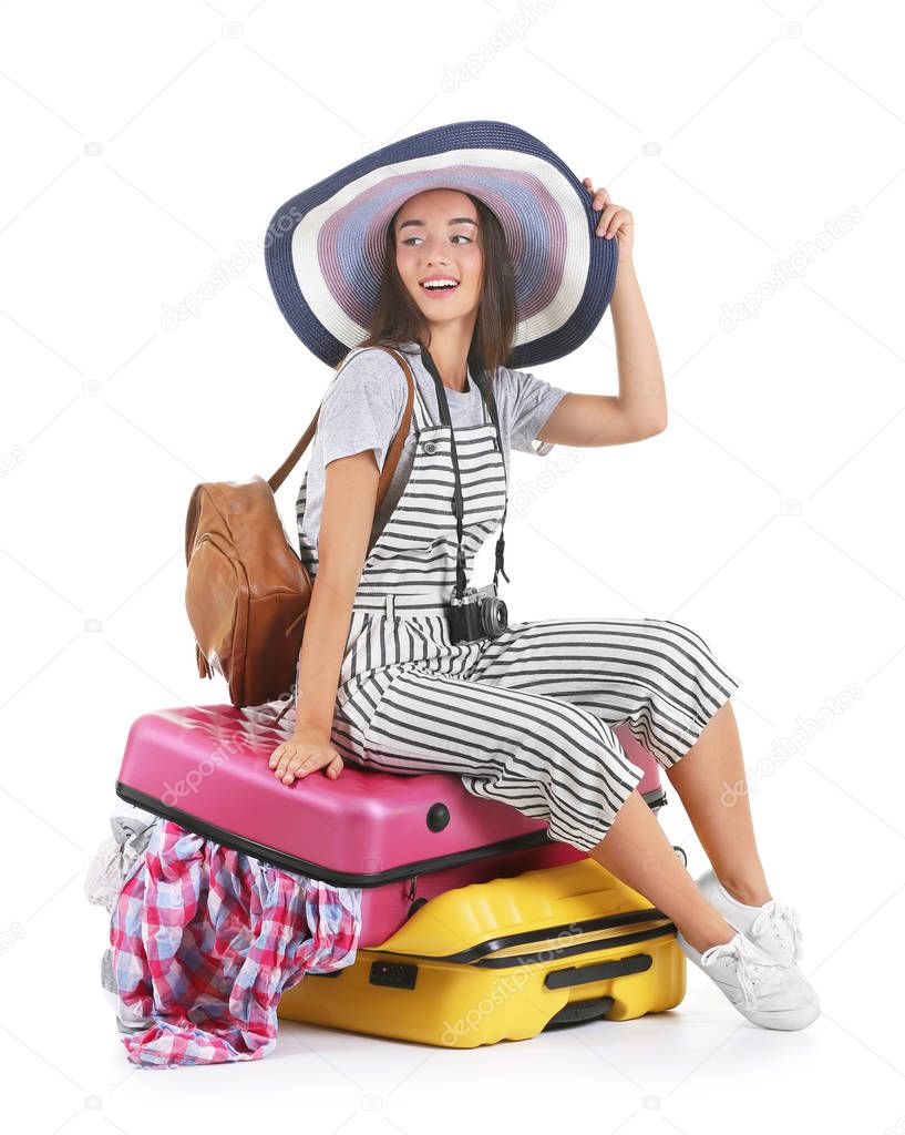 Attractive tourist sitting on suitcase  