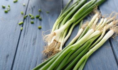 ahşap masa üzerinde yeşil soğan