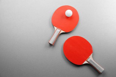Ping pong raketleri ve gri arka plan üzerinde topu