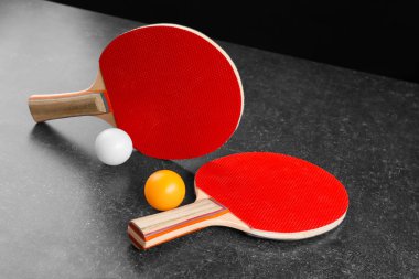 Ping pong raketleri ve topları gri masada