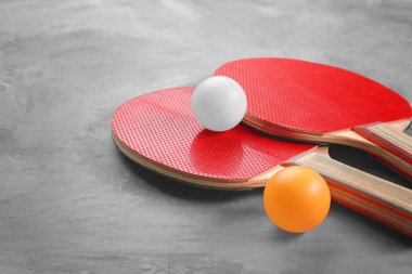 Ping pong raketleri ve topları gri arka plan üzerinde