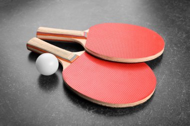 Ping pong raketleri ve gri arka plan üzerinde topu