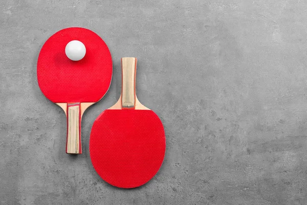 Ping pong rakety a míček na šedém pozadí — Stock fotografie
