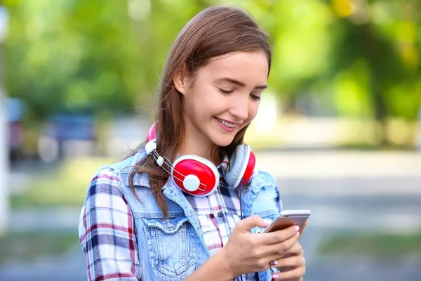 Привлекательная девушка-подросток с мобильным телефоном на открытом воздухе — стоковое фото