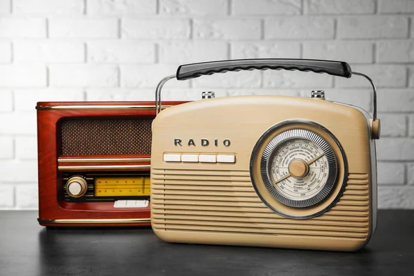 Retro radios on table near brick wall — Stock Photo, Image