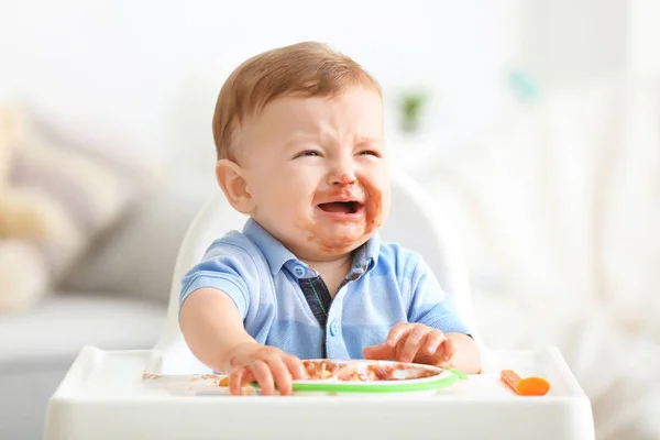 自宅のピューレを食べながら泣いているかわいい厄介な赤ちゃん — ストック写真