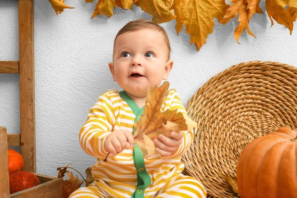 Entzückendes Baby im gestreiften Pyjama mit Blatt drinnen — Stockfoto