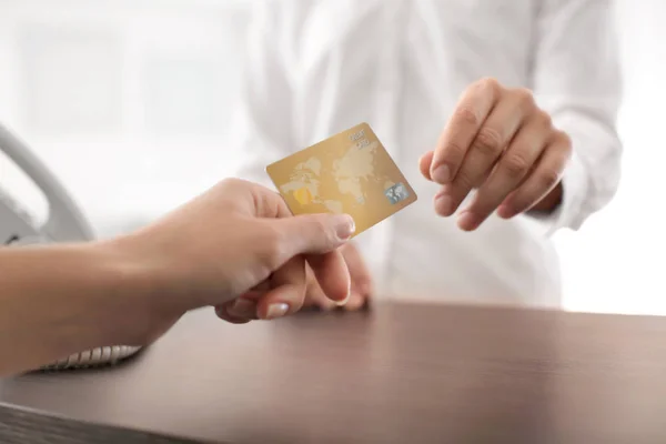 Клиент дает кредитную карту кассиру, крупным планом — стоковое фото