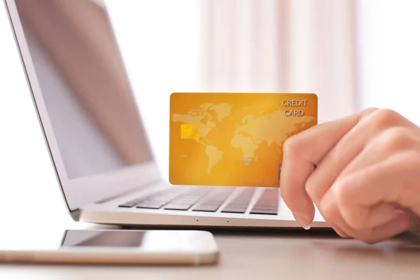Жінка з кредитною карткою і ноутбуком за столом, крупним планом — стокове фото