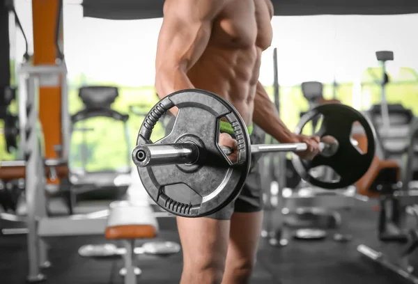 Muskulöser Mann trainiert mit Langhantel im Fitnessstudio — Stockfoto