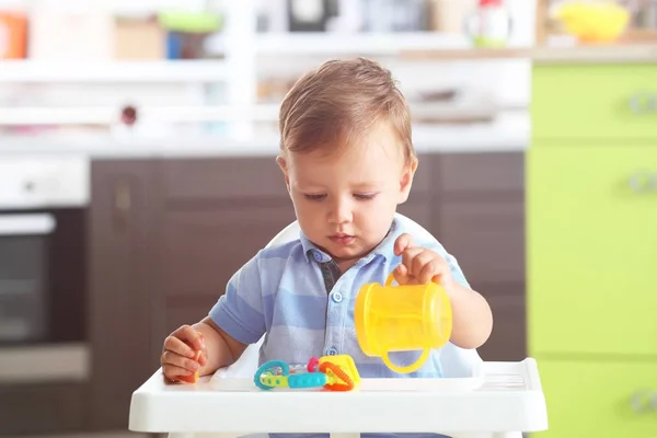 Adorable baby sitting in highchair at home — Stock Photo, Image