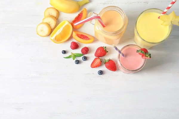 Glassware with different milkshakes on light background — Stock Photo, Image