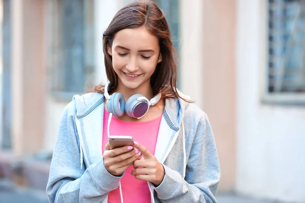 Привлекательная девушка-подросток с мобильным телефоном на открытом воздухе — стоковое фото