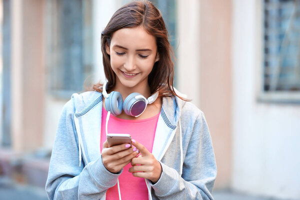 Attractive teenage girl with cell phone outdoors