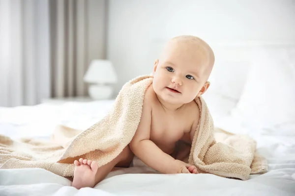 Pojke med handduk på sängen — Stockfoto