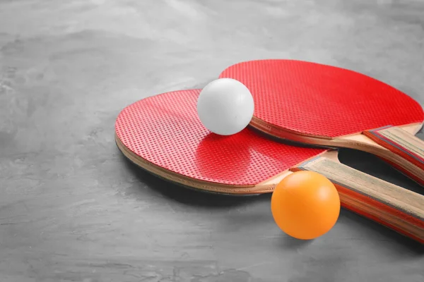 Ping pong raketleri ve topları gri arka plan üzerinde — Stok fotoğraf