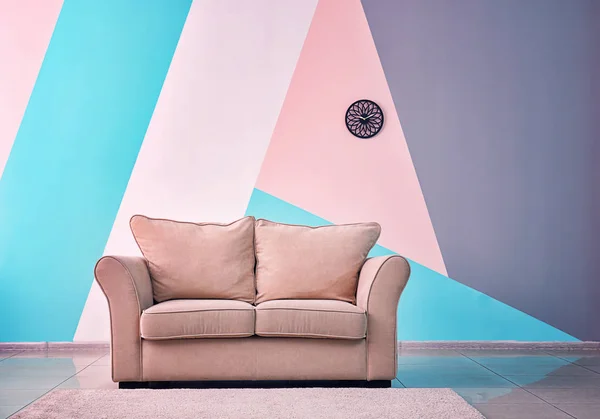 Acogedor sofá en fondo de pared de color —  Fotos de Stock