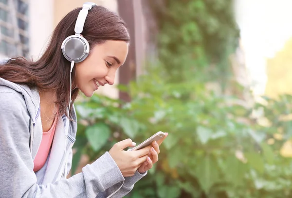 Attraktiva tonårig flicka Lyssna på musik utomhus — Stockfoto