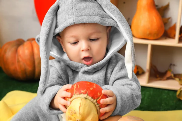 Adorabile bambino in costume da coniglietto con piccola zucca al chiuso — Foto Stock
