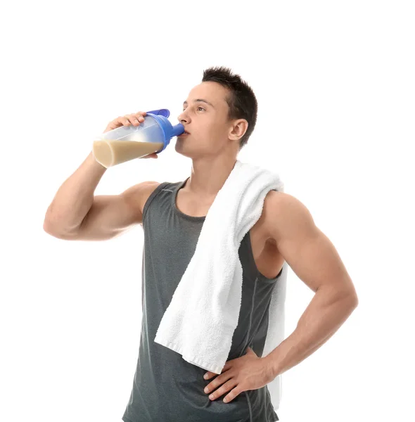 Bonito jovem bebendo batido de proteína no fundo branco — Fotografia de Stock