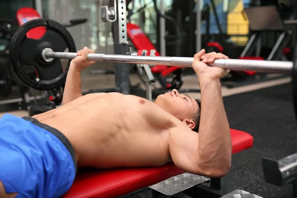 Musculoso hombre de entrenamiento con barra en el gimnasio — Foto de Stock