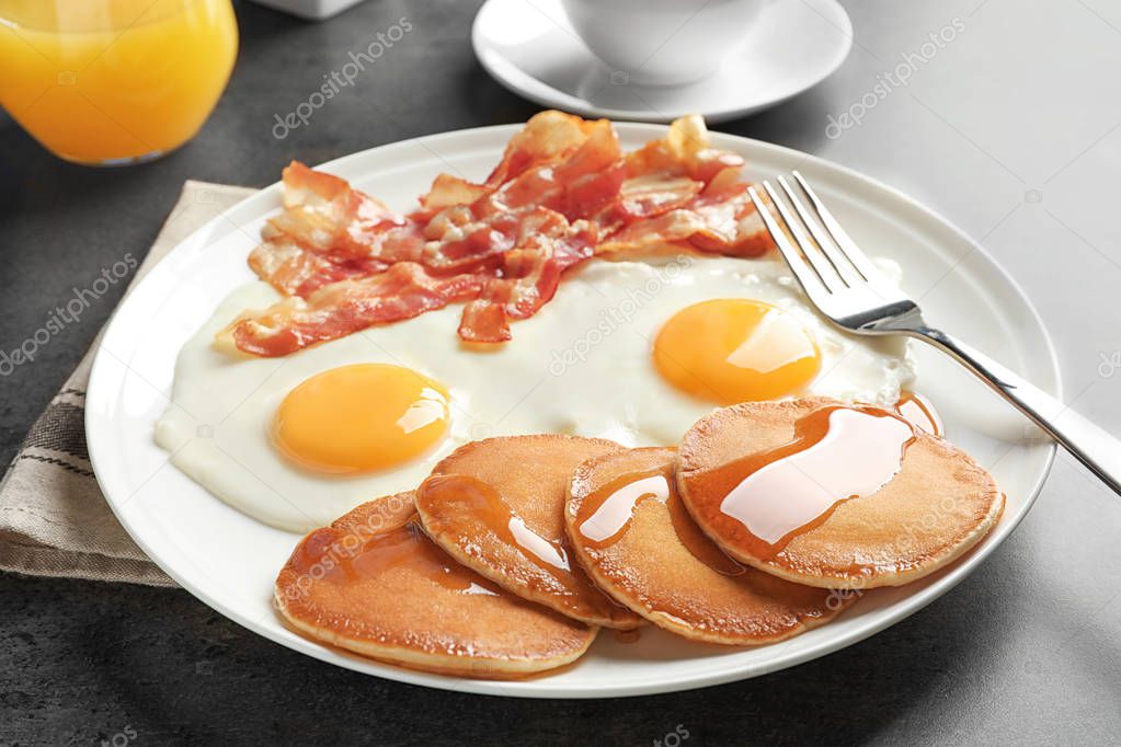 Tasty breakfast with pancakes, fried eggs and bacon 