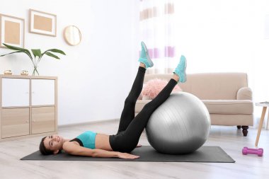 Güzel genç kadın fitness topu evde ile yapıyor