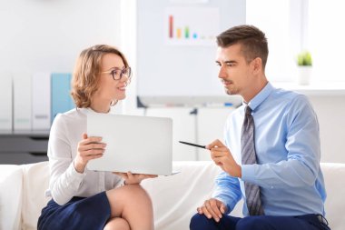 Genç adam ve kadın ofiste kanepede oturuyordu