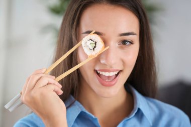 Suşi sarması olan güzel genç bir kadın. 