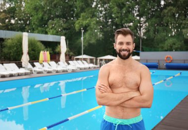 Yakışıklı genç adamın yanında mavi Yüzme Havuzu