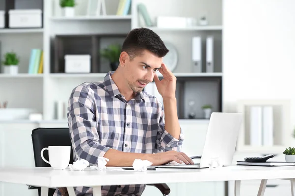 Homme attrayant avec ordinateur portable au bureau — Photo