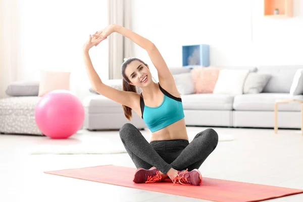 Belle jeune femme faisant des exercices à la maison — Photo