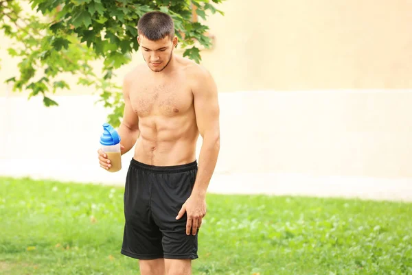 Handsome young man with protein shake — Stock Photo, Image