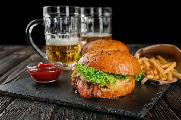 Sabrosa hamburguesa de carne en plato de pizarra — Foto de Stock