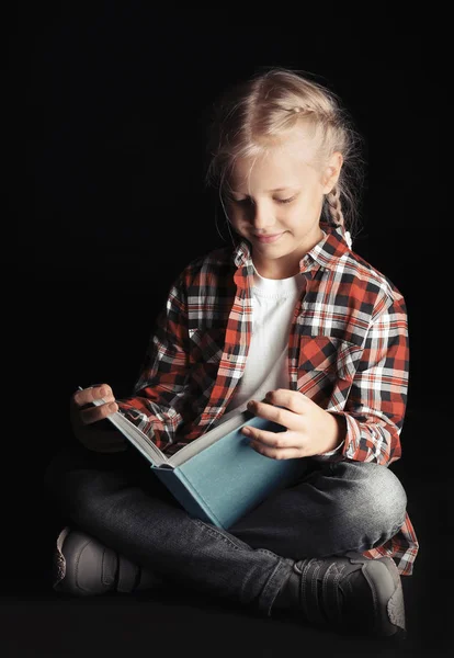 Kitap okuyan sevimli küçük bir kız. — Stok fotoğraf