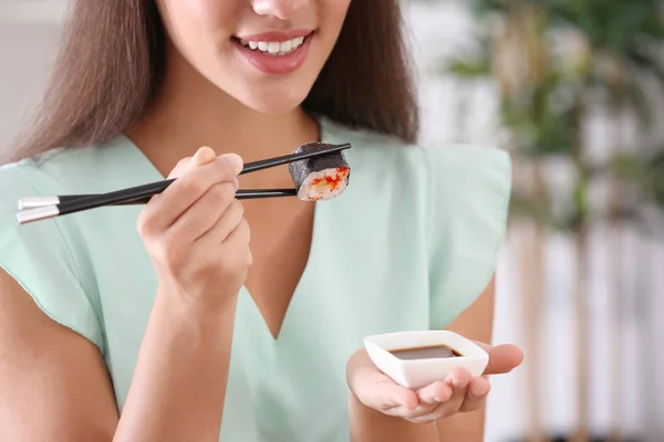 Jeune femme manger sushi roll — Photo