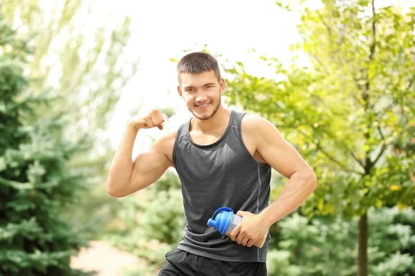 Handsome young man with protein shake — Stock Photo, Image
