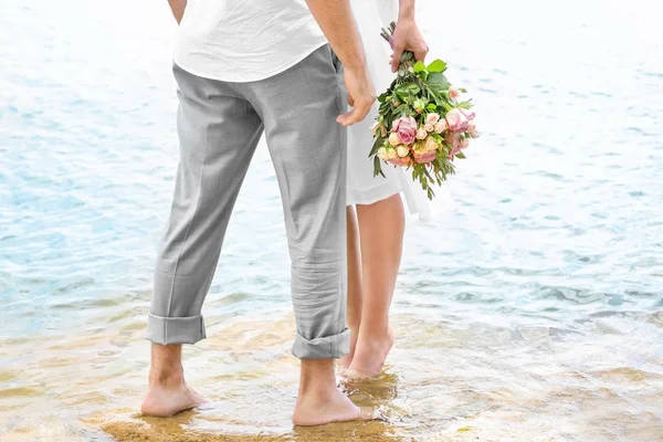 Pareja descalza en la orilla del mar — Foto de Stock