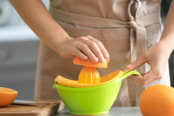 Mujer exprimiendo jugo de naranja madura — Foto de Stock