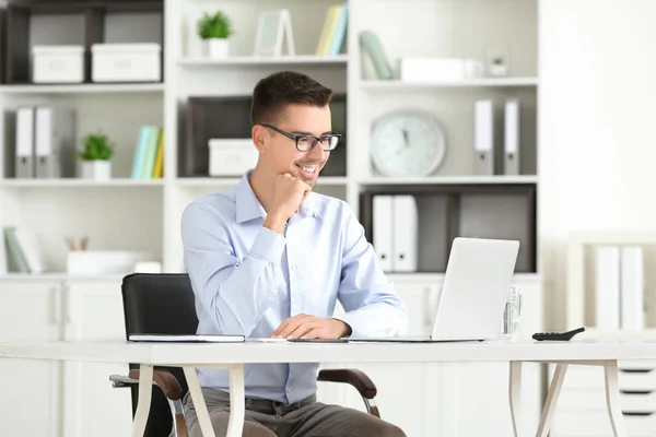 Homme attrayant avec ordinateur portable au bureau — Photo