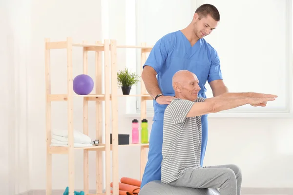 Fysiotherapeut werkt samen met patiënt in kliniek — Stockfoto